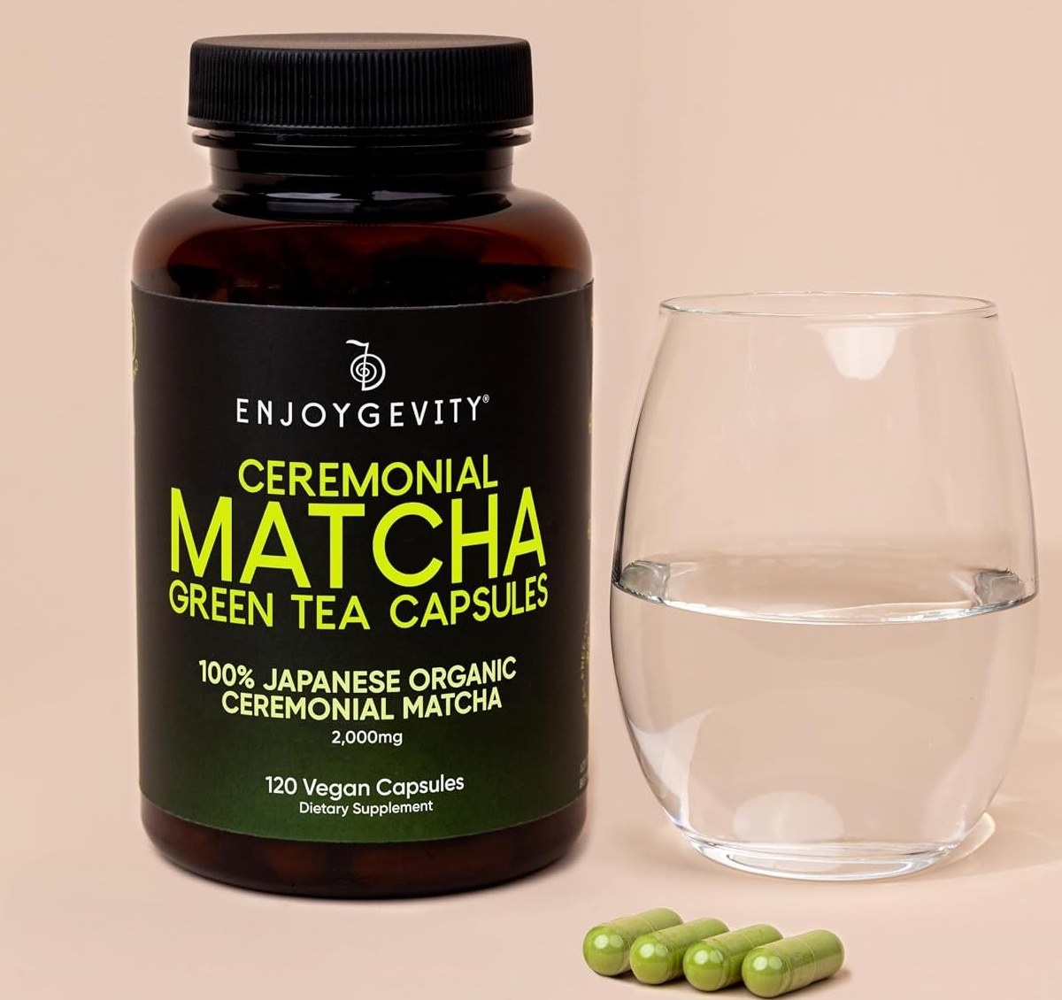 EnjoyGevity matcha bottle beside a glass of water with four green capsules